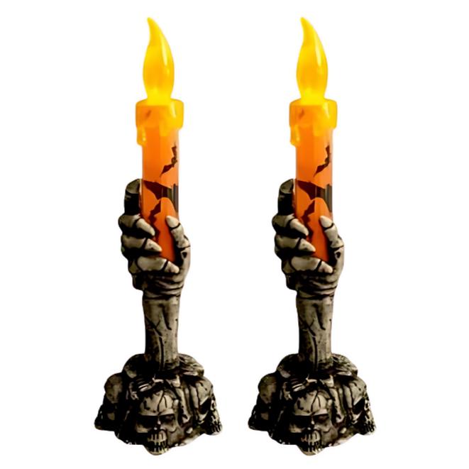 Halloween candle held by a skeleton hand on a skull base